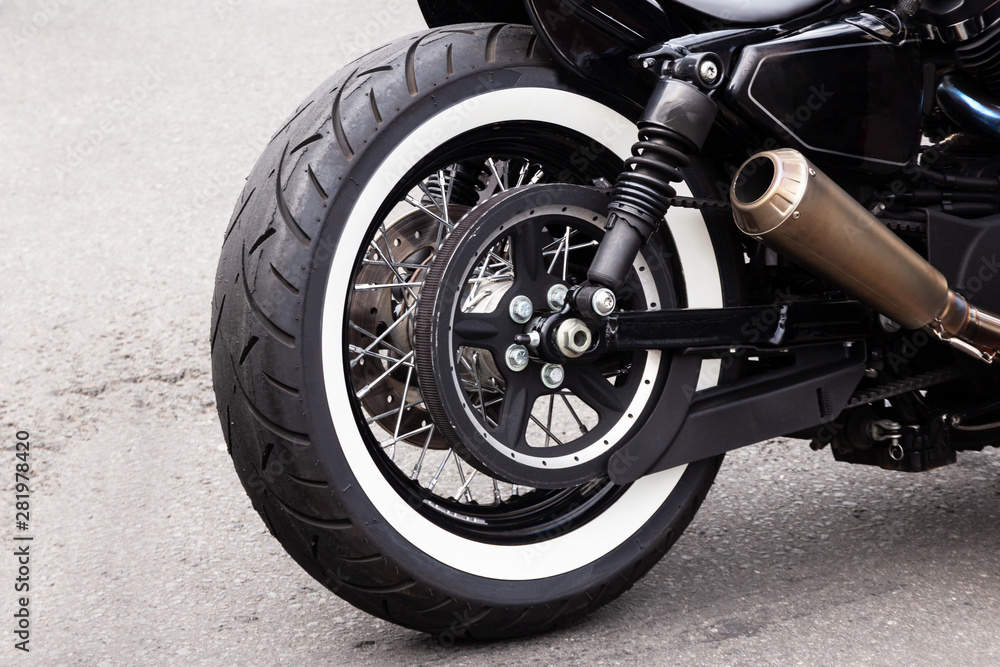 White stripe motorcycle rear wheel and steel exhaust pipe