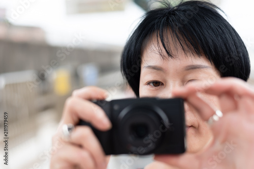 mature Asian woman using digital camera