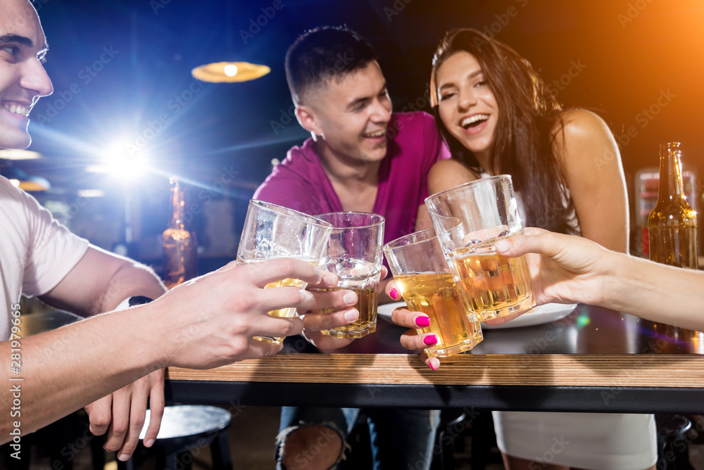 Cheerful friends in the pub. Drinking beer, talking, having fun. Cheerful friends in the pub. Drinking beer, talking, having fun.