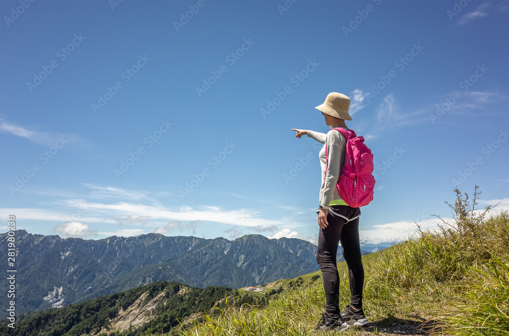 Asian mountain climbing woman pointing at far away