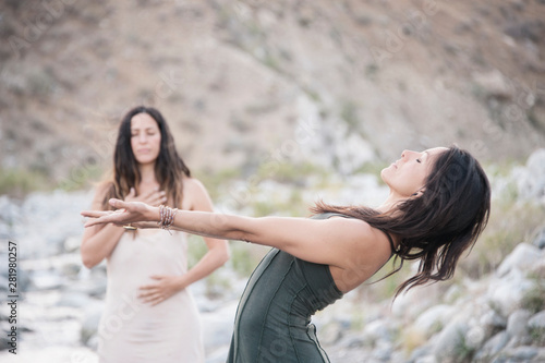 Two Wild Women dancing in desert wilderness nature.  photo