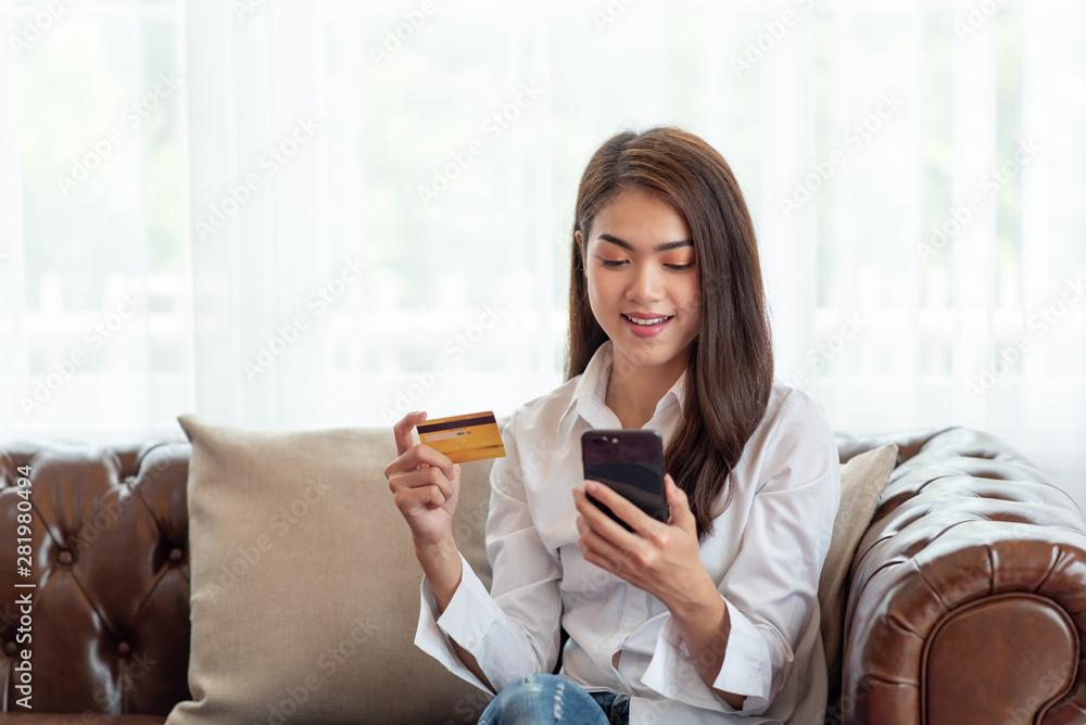 Young Asian woman holding credit card and using mobile phone, Online shopping concept Young Asian woman holding credit card and using mobile phone, Online shopping concept