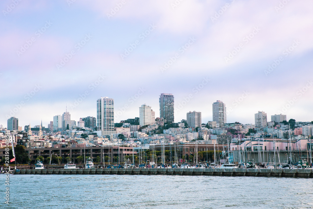 Obraz premium City of San Francisco California seen from the Bay with boats, docks, wharf and buildings of skyline in view.