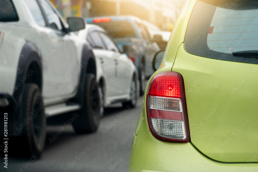 Brake of green car on asphalt roads during rush hours for travel or business work.