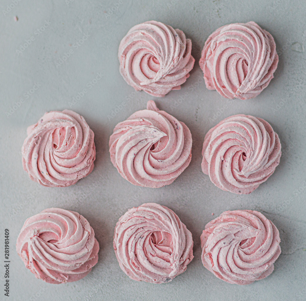 Meringue zephyr marshmallows lined up in a square on a light background, one already eaten. flat ley. Pink sweet homemade marshmallow. meringue on white background. Meringue zephyr marshmallows lined up in a square on a light background, one already eaten. flat ley. Pink sweet homemade marshmallow. meringue on white background.