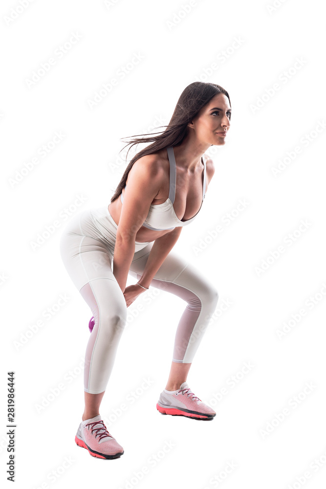 Dynamic action shot of fitness gym young woman crouching swinging with kettlebell. Full body isolated on white background. 