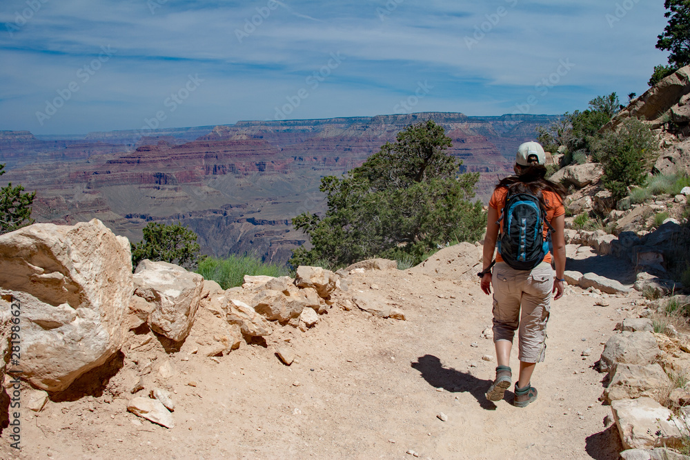 Young woman hiking on South Kaibab Trail in Grand Canyon National Park South Rim, Arizona on sunny summer afternoon.