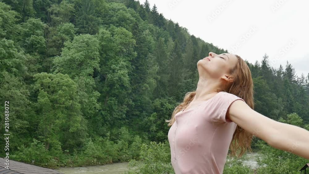 Happy curly girl in the mountains enjoys summer rain without an umbrella. The girl is happy and laughs cheerfully. beauty of nature Happy curly girl in the mountains enjoys summer rain without an umbrella. The girl is happy and laughs cheerfully. beauty of nature