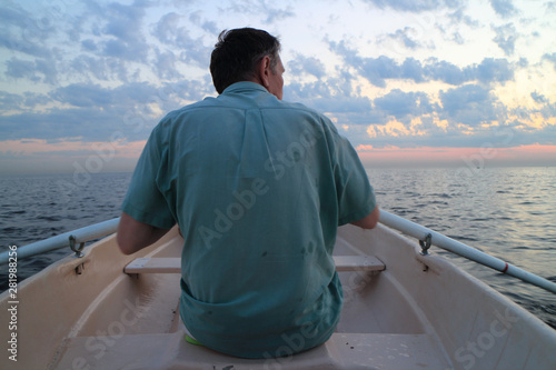 unrecognizable man on oars rowing boat rear view