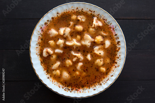 Turkish delicious traditional food Manti soup with tomato sauce, chickpea and dry mint