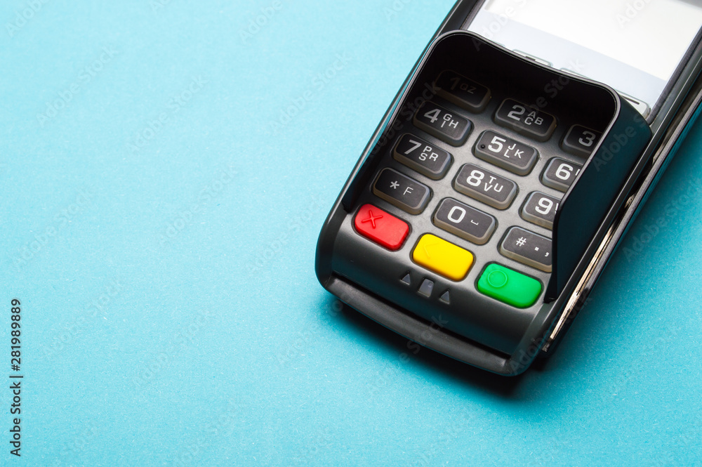 Credit card terminal on blue background. Close up of merchant payment device, card machine. Credit card terminal on blue background. Close up of merchant payment device, card machine.