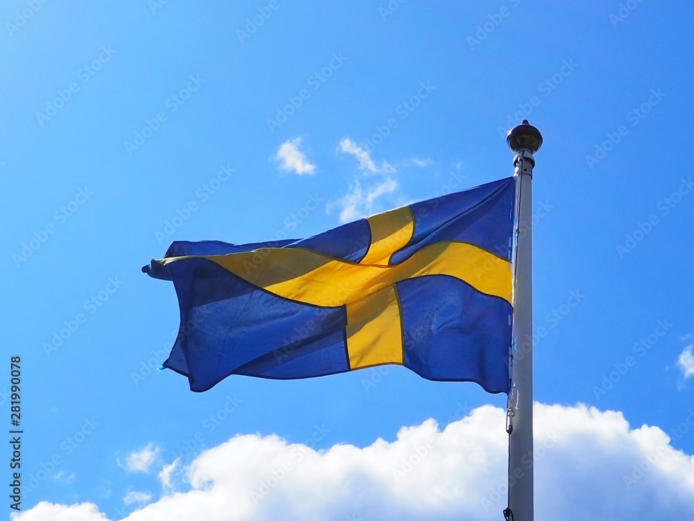 Fototapeta premium flag of sweden waving in the wind in front of blue sky