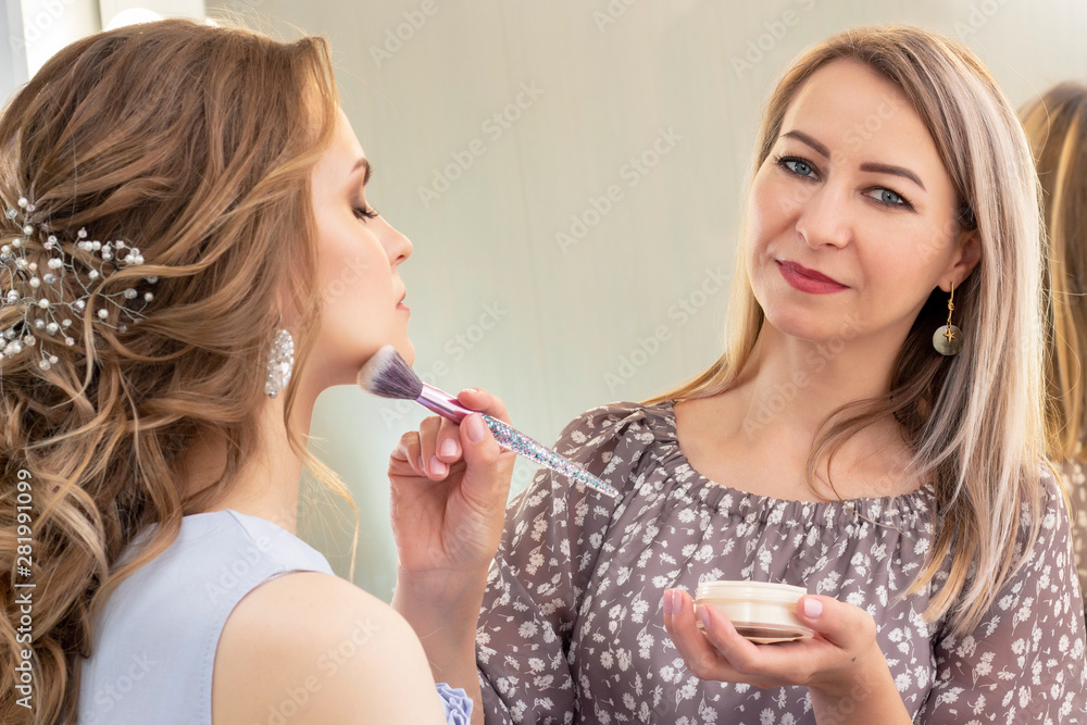 Makeup artist puts makeup on girl model. Brush powder on cheekbones and face. beautiful girl model, portrait. Nude colors in makeup. wedding, evening makeup. Makeup artist puts makeup on girl model. Brush powder on cheekbones and face. beautiful girl model, portrait. Nude colors in makeup. wedding, evening makeup.