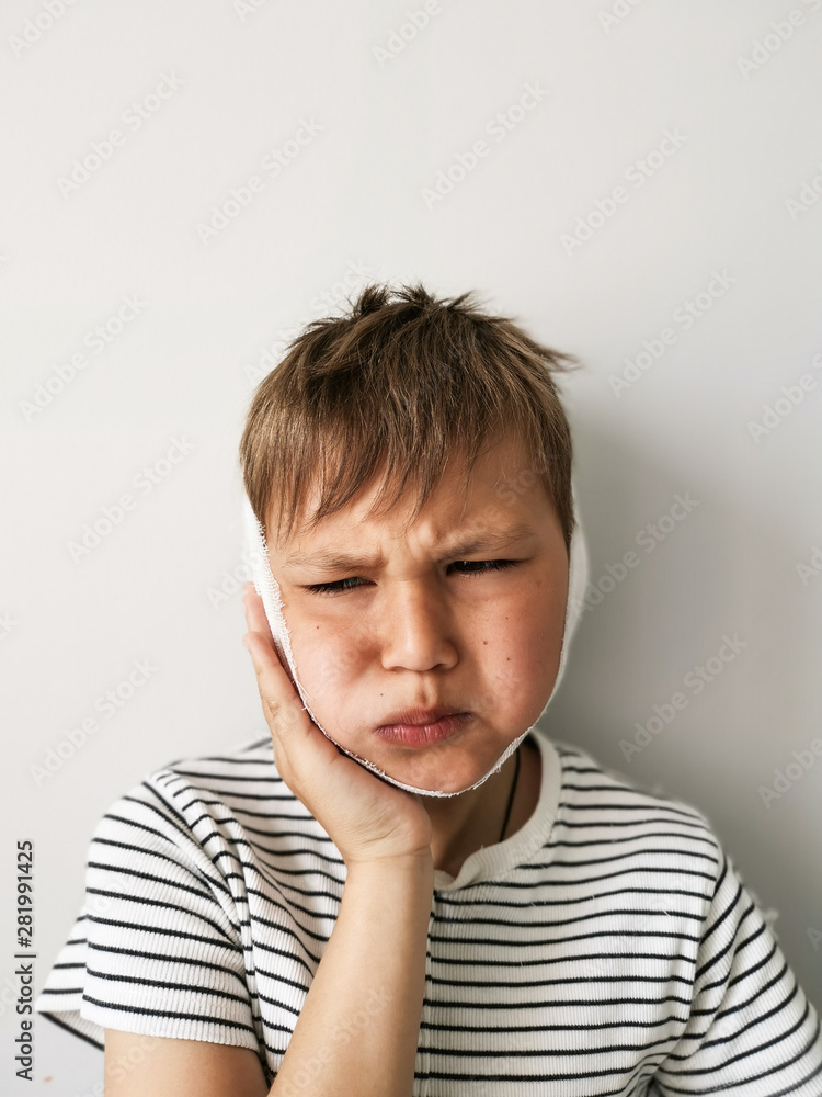 Little boy with toothache over gray background. Child toothache with sensitive tooth ache problem touching on face the part with pain Little boy with toothache over gray background. Child toothache with sensitive tooth ache problem touching on face the part with pain