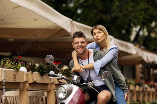 Happy couple of tourist travelers around city with motorbike scooter