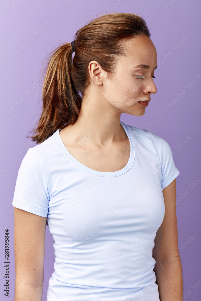 attractive girl with ponytail looking down, close up side view portrait, preparation for a procedure. attractive girl with ponytail looking down, close up side view portrait, preparation for a procedure.