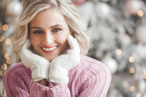 Closeup portrait of very beautiful young woman on christmas background. Attractive female portrait indoors. Perfect blond woman.