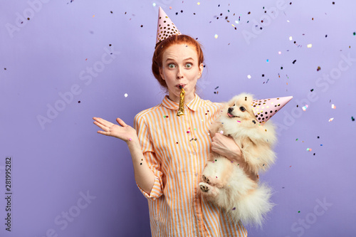 good looking girl with her fluffy dog loks positively. magic time, wonder concept. close up portrait photo