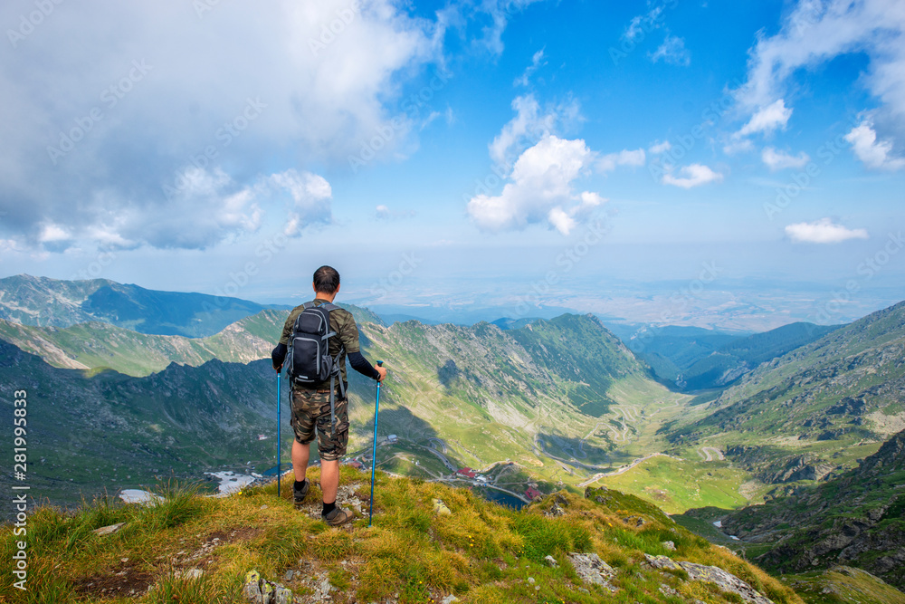 Successful active man hiker on top of mountain enjoying the view. Travel sport lifestyle concept Successful active man hiker on top of mountain enjoying the view. Travel sport lifestyle concept