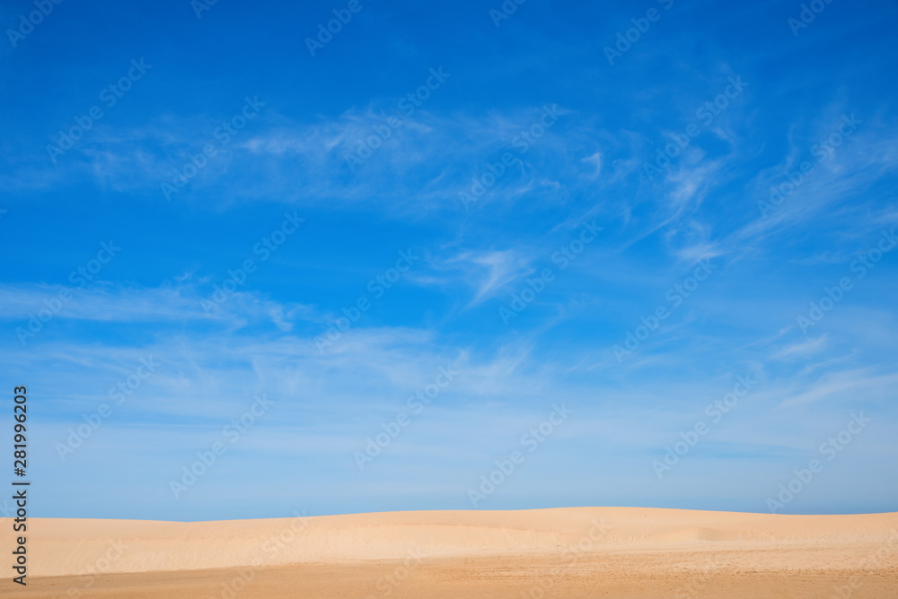 Sandstrand mit feinem Sand, grosse Fläche blauer Himmel mit Schleierwolken und Platz für Text Sandstrand mit feinem Sand, grosse Fläche blauer Himmel mit Schleierwolken und Platz für Text