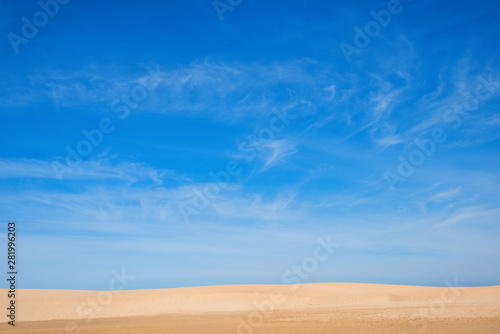 Sandstrand mit feinem Sand, grosse Fläche blauer Himmel mit Schleierwolken und Platz für Text