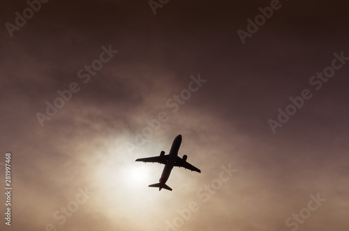 Airliner silhouette visible under a gash in the clouds