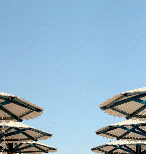 Six hats of beach umbrellas against the blue sunny sky in summer