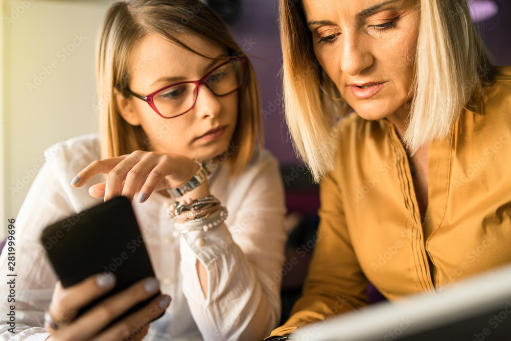 Business women using smart mobile phones app on a coffee brake at the company to check data mail information consulting Business women using smart mobile phones app on a coffee brake at the company to check data mail information consulting