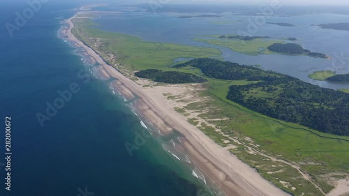 The nutrient-rich waters of the Atlantic Ocean bathe a scenic beach on Cape Cod, Massachusetts. This beautiful area of New England, not too far from Boston, is a popular summer vacation destination. photo