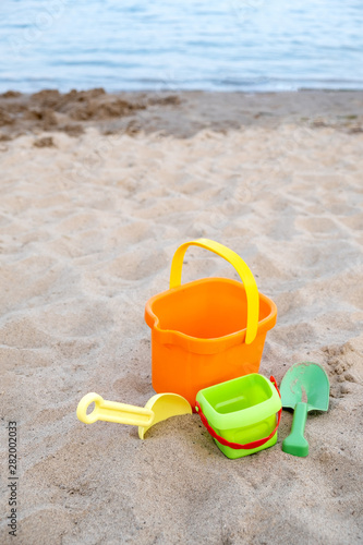 Children's toys lie on the sand on the beach. Family vacation on the beach.
