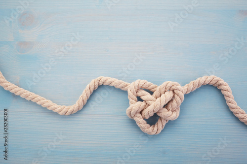 Heart shaped knot on blue wooden background photo