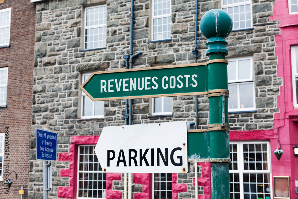 Obraz premium Conceptual hand writing showing Revenues Costs. Concept meaning Total amount of money in Manufacturing and Delivery a product Advertisement concept with empty copy space on the road sign