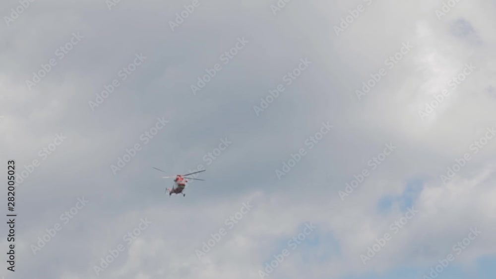 Red helicopter flies overhead in the mountains of America. Down up of a helicopter flying over a mountain range during the landing of tourists on the cliffs. Red helicopter flies overhead in the mountains of America. Down up of a helicopter flying over a mountain range during the landing of tourists on the cliffs.