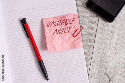 Conceptual hand writing showing Valuable Asset. Concept meaning Your most valuable asset is your ability or capacity Wrinkle paper notebook and stationary placed on wooden background photo