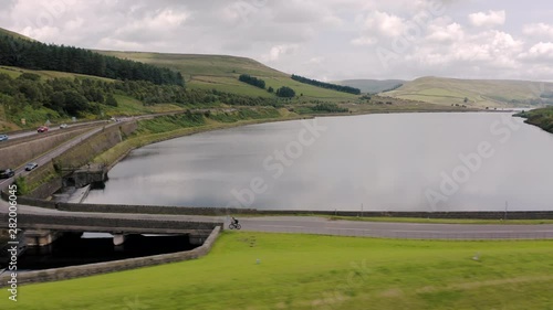 Aerial view of a cyclist cycling through the Peak District National Park over a Dam between Woodhead and Torside, Summer 2019 photo