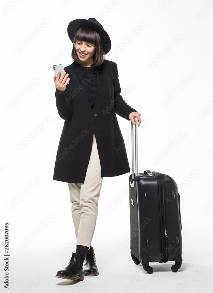 Portrait of young woman walking with travel bag and using mobile phone isolated on white background Portrait of young woman walking with travel bag and using mobile phone isolated on white background