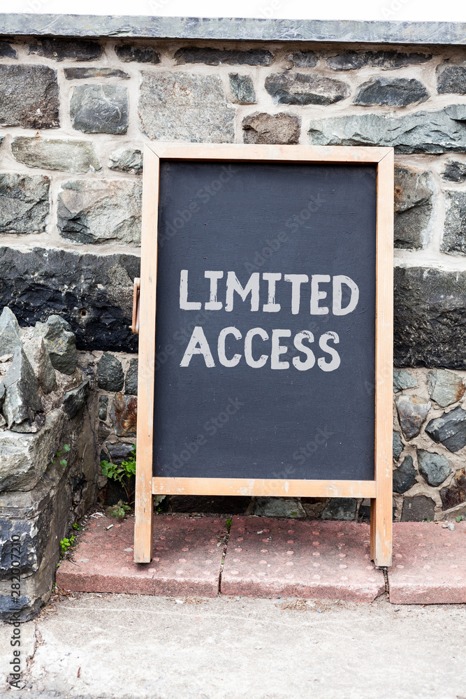 Fototapeta premium Handwriting text writing Limited Access. Conceptual photo Having access restricted to a quite small number of points Empty black board with copy space for advertising. Blank dark board