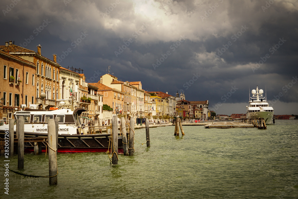 VENICE, ITALY - JULY,5: Stormy day in the center of Venice, boats, buildings, bridges under the heavy clouds