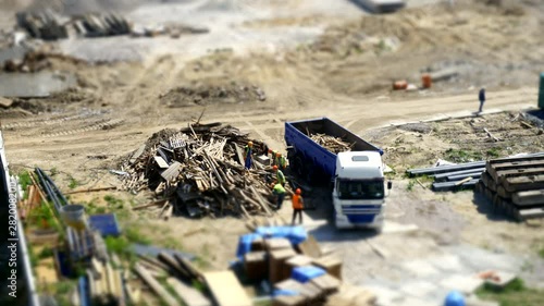 View of the construction site where workers are lading lamber into dump truck