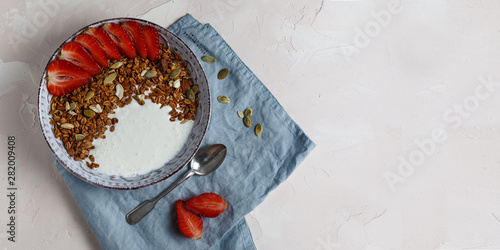 Granola with strawberries, nuts, pumpkin seeds and yogurt
