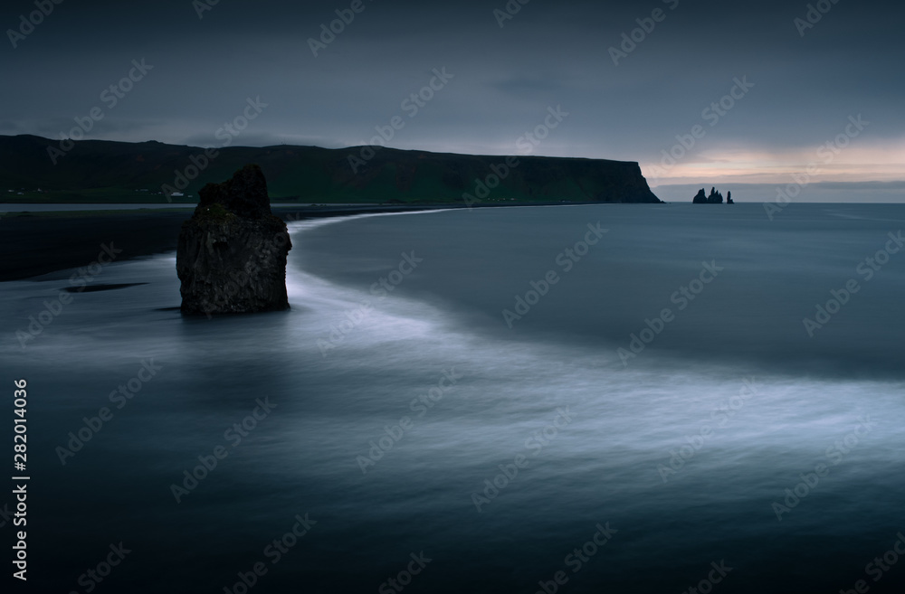 Scenic view from Dyrholaey to Reynisfjara beach against cloudy sky.