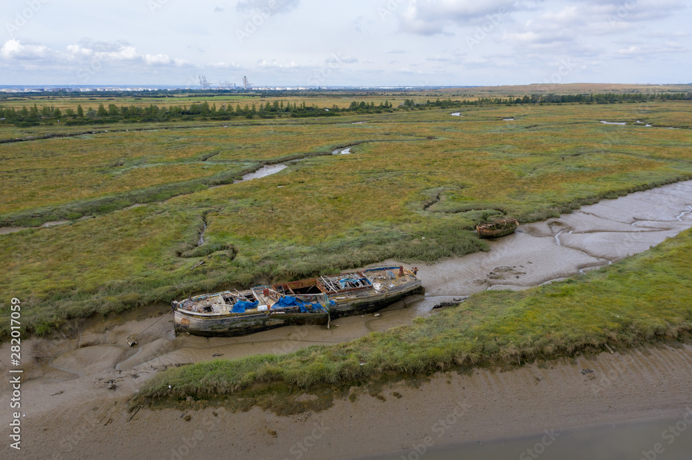 Fototapeta premium Aerial view of an abandoned boat on Benfleet marshes mudflats, Essex, England