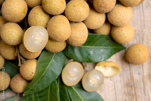 Longan fruit with leafs on wooden background