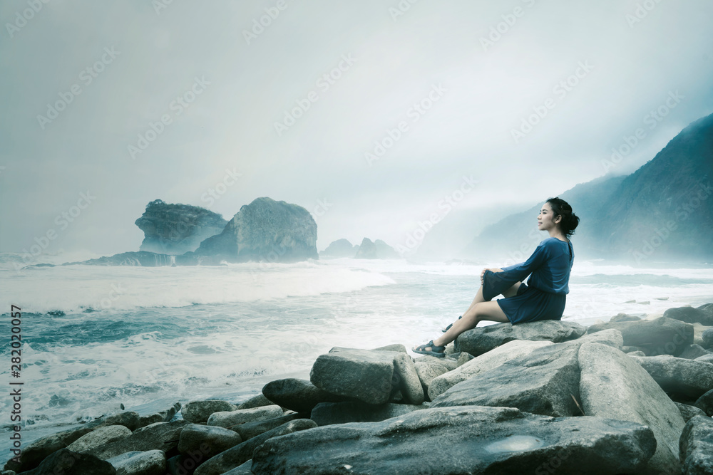 Beautiful woman enjoys a foggy Papuma beach view Beautiful woman enjoys a foggy Papuma beach view