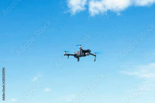 Black drone in the blue sky