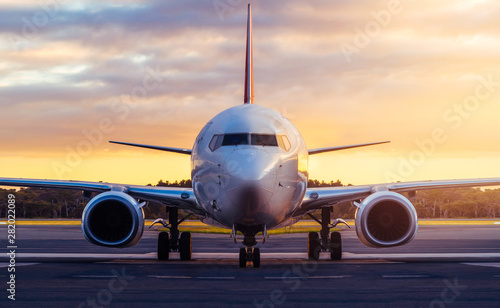 Sunset view of airplane on airport runway under dramatic sky in Hobart,Tasmania, Australia. Aviation technology and world travel concept.