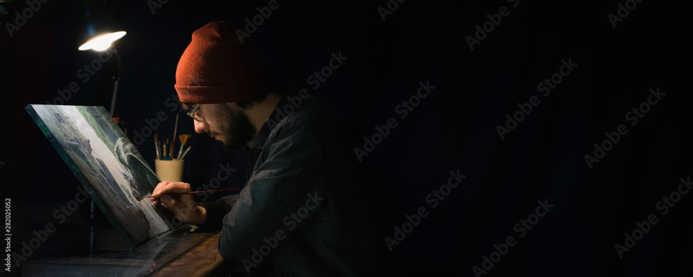 Fototapeta premium man painting a picture in the dark 