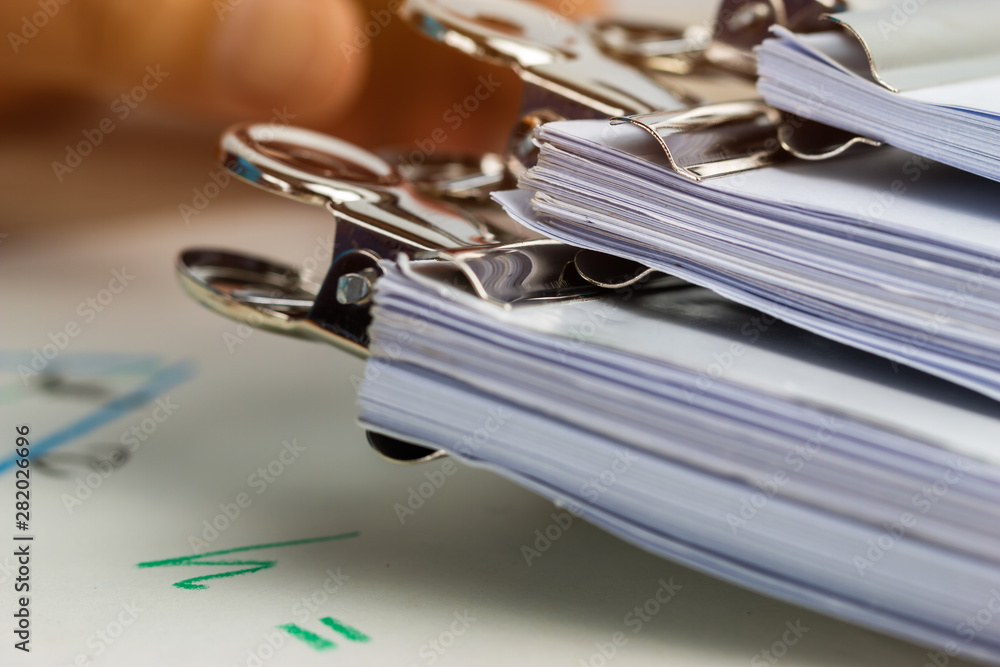 Silver clips paper stacks of piles unfinished papers documents files in accounting business report on desk in busy office, Paperwork of financial folder at business workplace concept Silver clips paper stacks of piles unfinished papers documents files in accounting business report on desk in busy office, Paperwork of financial folder at business workplace concept