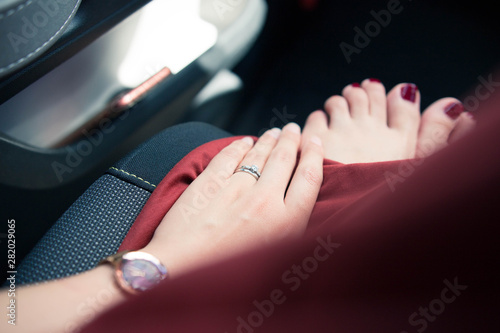 赤いワンピース、赤いペディキュア、指輪をした女の人（車内）