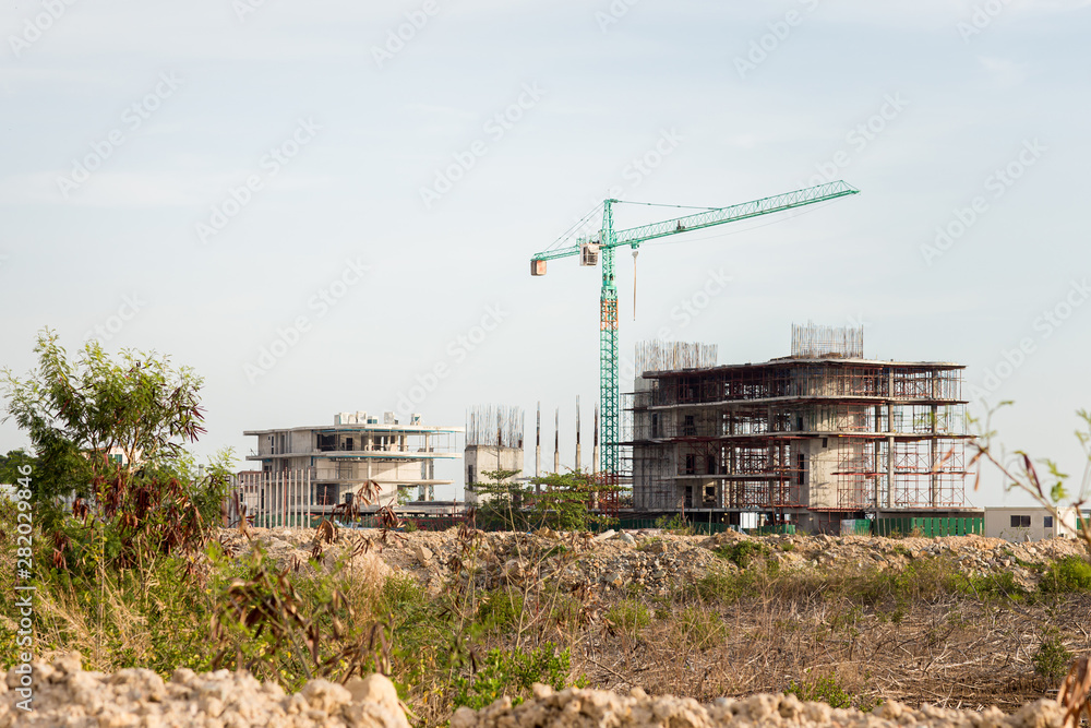 Construction site including several cranes working on a building complex. Construction Site, construction machinery,factory